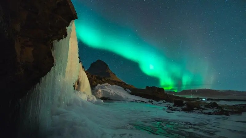 Northern lights dancing over Icelandic landscape